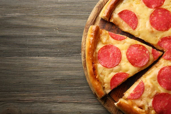 Heiße leckere Pizza mit Salami auf Holzboden — Stockfoto