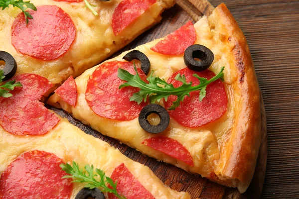 Hot tasty pizza with salami and olives on wooden background, close up — Stock Photo, Image