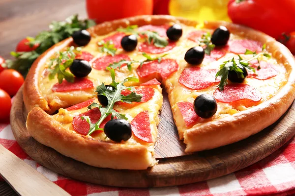 Pizza lezat dengan salami dan zaitun dengan latar belakang kayu, tutup — Stok Foto