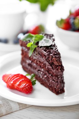 Tabakta, açık renkli Çikolata kremalı ve taze çilek ile çikolatalı kek