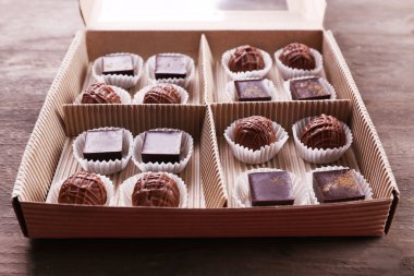 Lezzetli çikolata şekerleme kağıt kutusunda ahşap arka plan, yakın çekim