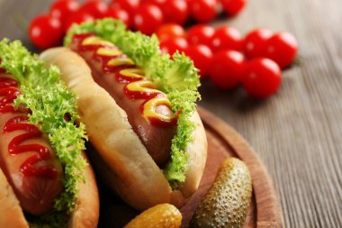 Ahşap masa üzerinde sebze ile lezzetli hot-dogs