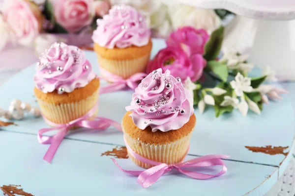 Cupcakes saborosos na bandeja, no fundo claro — Fotografia de Stock
