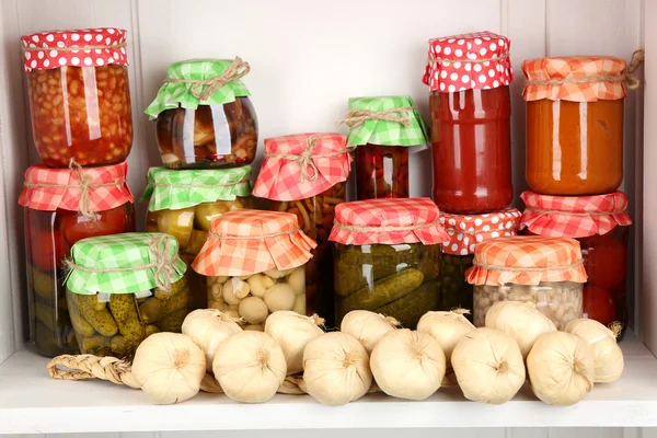 Frascos con verduras en escabeche y frijoles en estante de madera — Foto de Stock