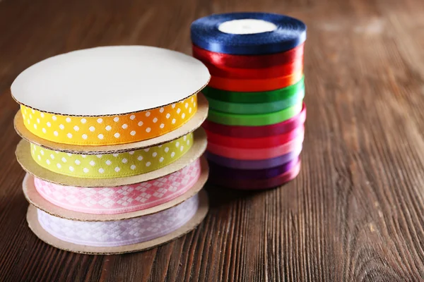 Spools of color ribbon on wooden background — Stock Photo, Image