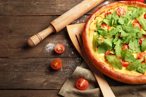 Pizza Margherita with arugula and kitchenware on wooden table — Stock Photo, Image