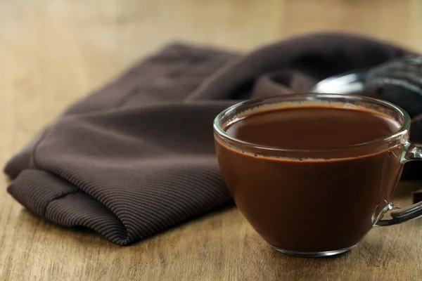 Copo de cacau com chocolate e guardanapo na mesa de madeira — Fotografia de Stock