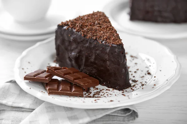 Chocolate cake met chocolade crème op plaat, op lichte achtergrond — Stockfoto