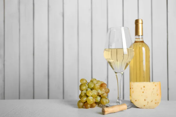 Wein mit Trauben und Käse auf hölzernem Hintergrund — Stockfoto