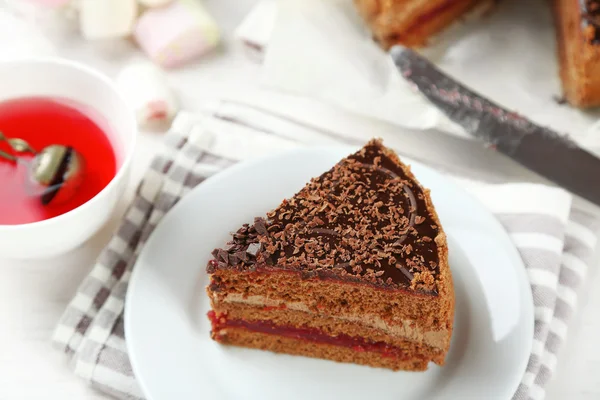 Chocoladetaart gesneden op plaat, op houten tafel achtergrond — Stockfoto