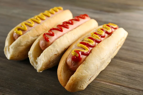 Hotdogs savoureux sur fond en bois — Photo