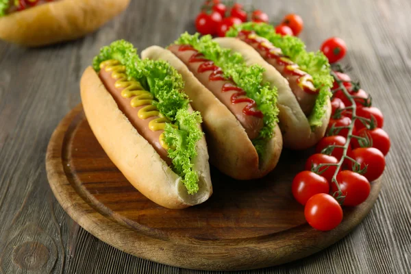 Ahşap arka plan üzerinde domates ile lezzetli hot-dogs — Stok fotoğraf