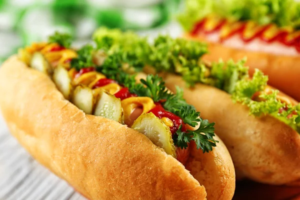 Delicious üzerinde beyaz ahşap masa hot-dogs, yakın çekim — Stok fotoğraf