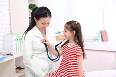 Bir çocuğu muayene eden doktor. 