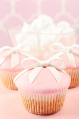 Lezzetli kek emzik renkli arka plan üzerinde yay ve bebek ayakkabı ile