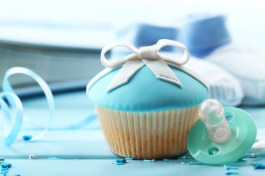 Renk ahşap arka plan üzerinde yay ve bebek ayakkabı ile lezzetli kek