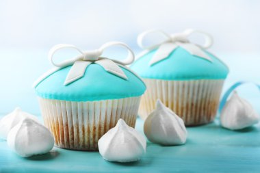 Parlak arka plan üzerinde renkli ahşap masa üzerinde yay ile lezzetli kek