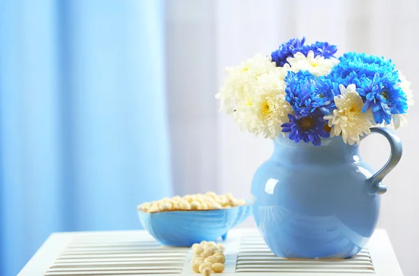 罐子有鲜花，同在一个房间里的桌子上的糖果碗 — 图库照片