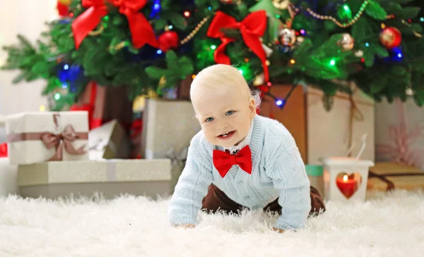Funny baby på julgran på bakgrund — Stockfoto