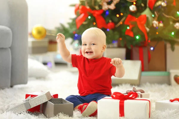 Baby met geschenkdozen en kerstboom — Stockfoto