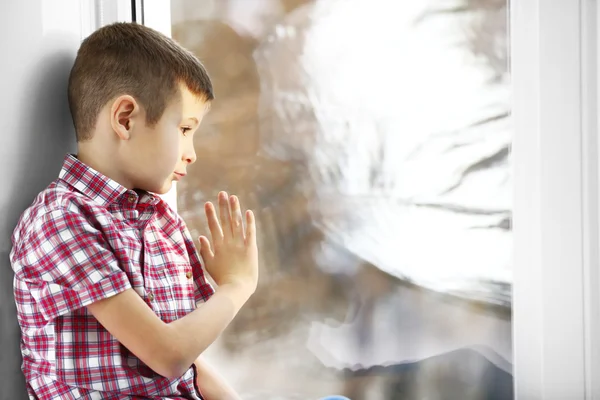 Boy sitting near window — Stock Photo, Image