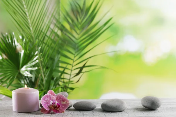 Spa composition of candle, stones and orchid on blurred background — Stock Photo, Image