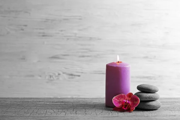 Spa composition of candle, stones and orchid on light background — Stok fotoğraf