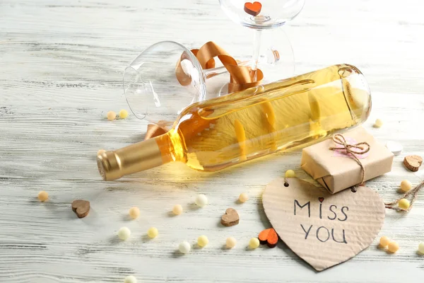 Láska koncept - víno láhev s dekoracemi na bílém pozadí dřevěná, zblízka — Stock fotografie