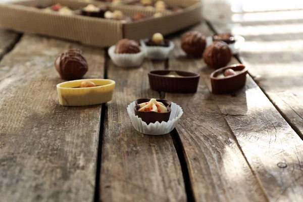 Diverse gustose caramelle al cioccolato sul tavolo di legno, da vicino — Foto Stock
