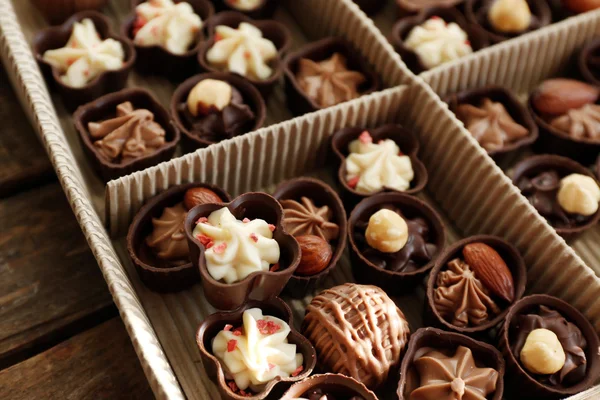 Doces de chocolate diferentes na caixa de papel, close-up — Fotografia de Stock