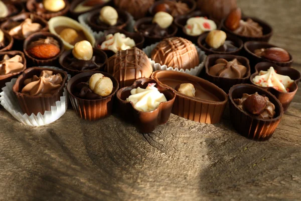 Delicious chocolate candies on wooden background, close up — Stock Photo, Image