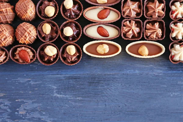 Köstliche Schokoladenbonbons auf blauem Holzhintergrund — Stockfoto