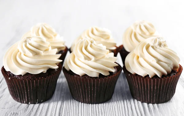 Tasty cupcakes on white wooden background, close up — Stock Photo, Image