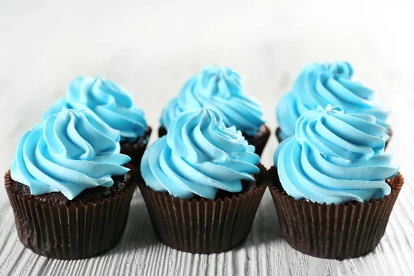 Delicious cupcakes on white wooden background, close up — Stock Photo, Image