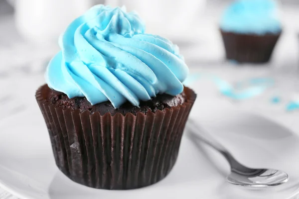 Delicioso cupcake de chocolate com creme azul na mesa de madeira decorada, close-up — Fotografia de Stock