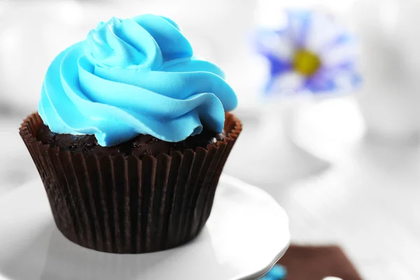 Delicioso cupcake de chocolate com creme azul na mesa servida, close-up — Fotografia de Stock