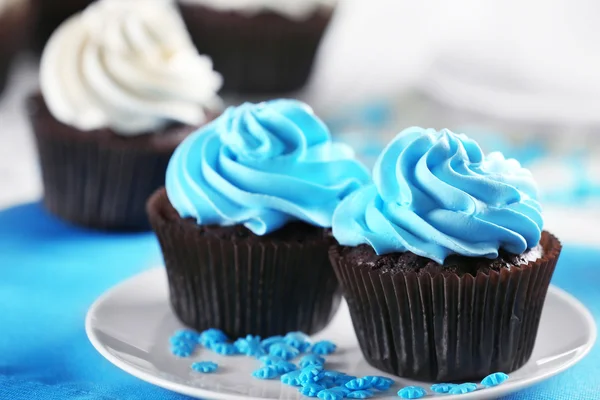 Süslü ahşap masa üzerinde mavi krem ile lezzetli çikolata cupcakes yakın çekim — Stok fotoğraf