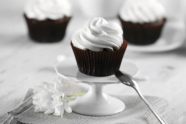 Heerlijke chocolade cupcake met crème op geserveerd tafel, close-up — Stockfoto