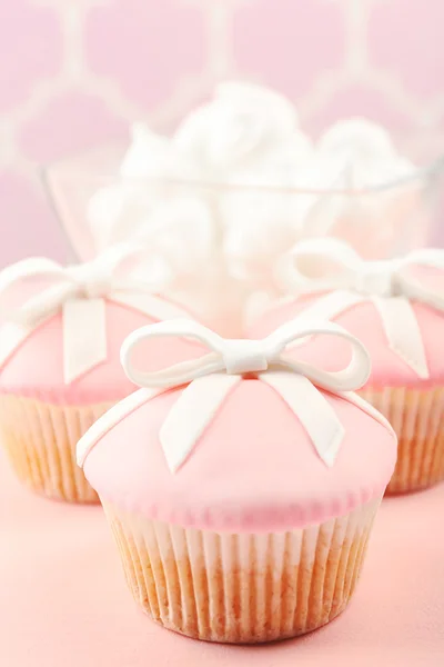 Tasty cupcake with bow and baby shoes, pacifier on color background — Stock Photo, Image