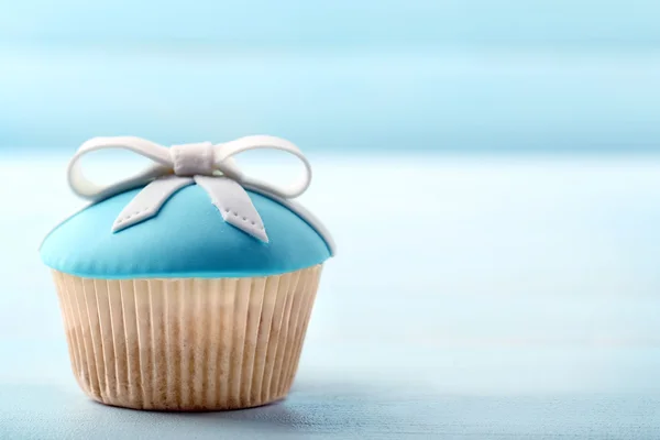 Gâteau savoureux avec arc sur fond en bois de couleur — Photo