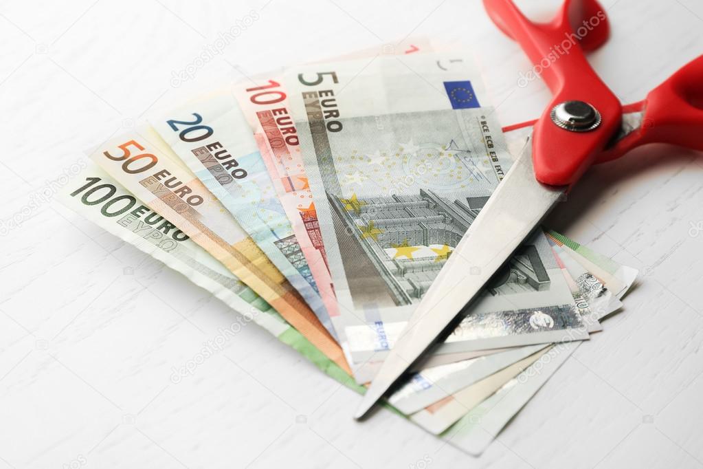 Scissors cuts different euro banknote