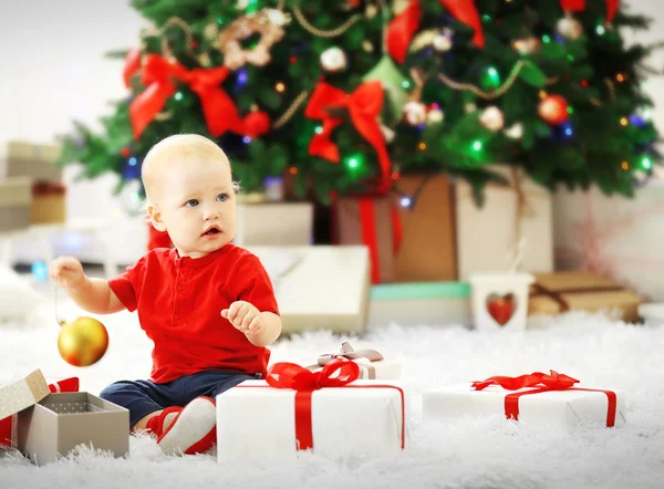Baby met geschenkdozen en kerstboom — Stockfoto