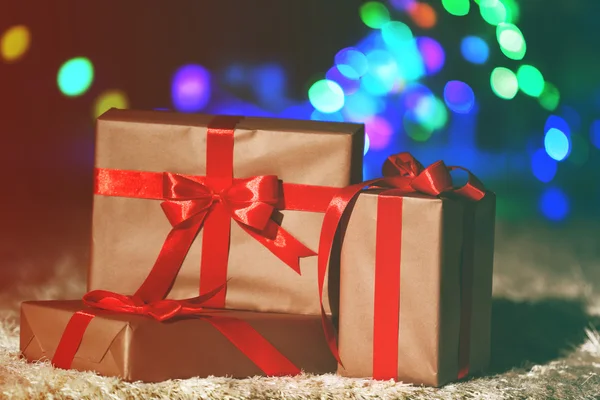Karácsonyi ajándék dobozok, piros szalag a földön, közelről — Stock Fotó
