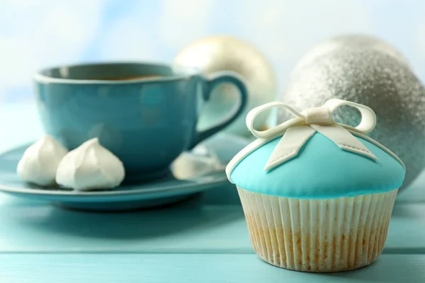 弓、コーヒー カップと木製の色の背景上のクリスマスのおもちゃでおいしいカップケーキ — ストック写真
