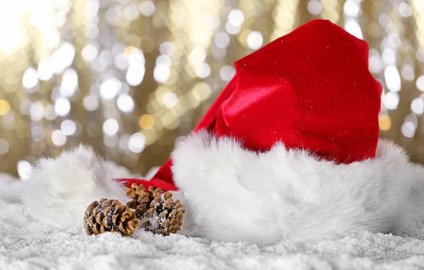 Santa Claus red hat s vánoční ozdoby na lesklém pozadí, zblízka — Stock fotografie