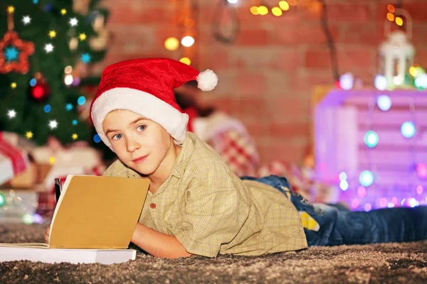 Pojke skrift i anteckningsboken på en jul — Stockfoto