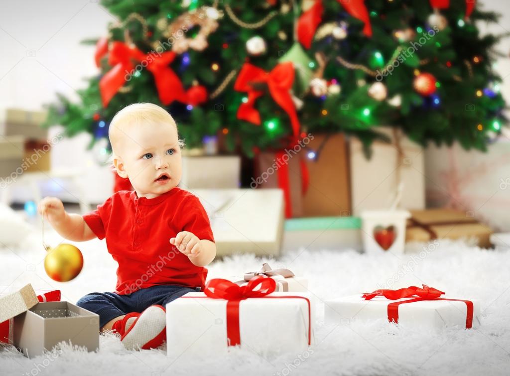 baby with gift boxes and Christmas tree