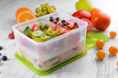 Lezzetli yemek plastik kaplarda ahşap masa yakın çekim