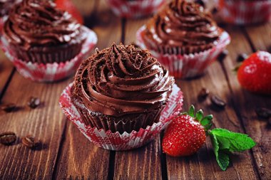 Çikolata cupcakes ve ahşap arka plan üzerinde çilek