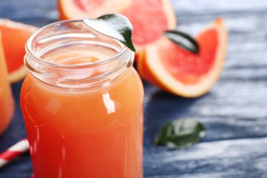 Greyfurt suyu şişeleri ve koyu mavi ahşap zemin üzerine taze meyve